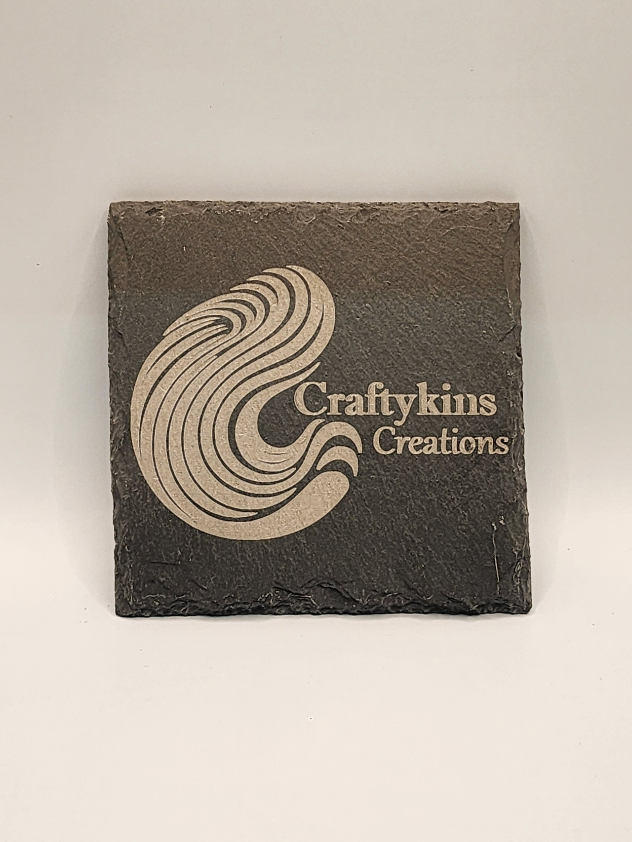 Craftykins Creations logo printed on slate in the workshop
